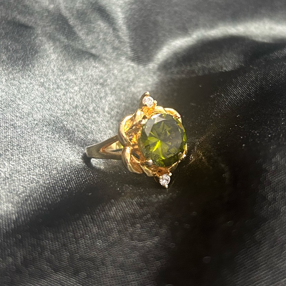 Gold tone ring with large green gem